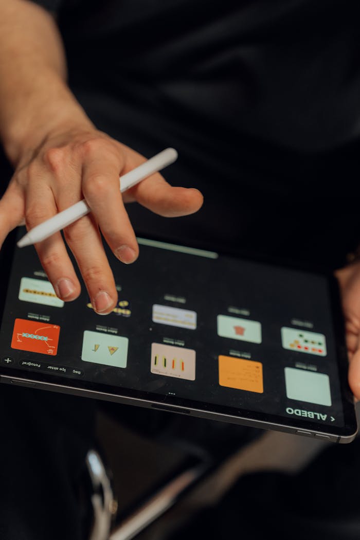 A person working on a digital tablet with a stylus, creating designs using an application.